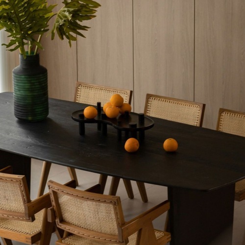a dining room table with chairs and a plant